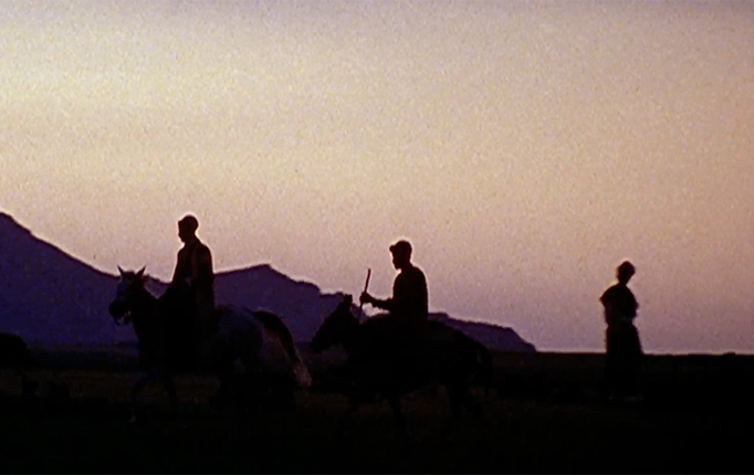 Three members of the nomadic Bakhtiari Tribe of Iran ride their horses through the valley at dusk.